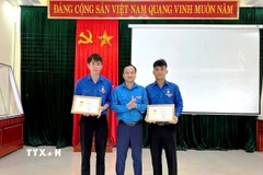 Thừa ủy quyền của Ban Bí thư Trung ương Đoàn, Phó Bí thư Tỉnh đoàn Quảng Trị Nguyễn Quốc Toản trao tặng Huy hiệu “Tuổi trẻ dũng cảm” cho đoàn viên Võ Hoàng Vũ và Nguyễn Võ Huy Công. (Ảnh: TTXVN phát)
