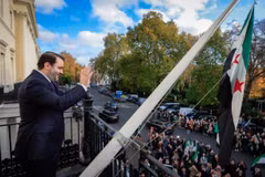 Ngoại trưởng Syria Asaad al-Shaibani vẫy tay với đám đông từ ban công Đại sứ quán nước này ở trung tâm thủ đô London, Anh, ngày 13/11. (Nguồn: X)