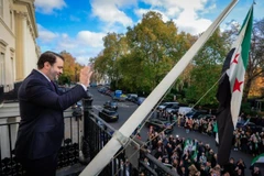 Ngoại trưởng Syria Asaad al-Shaibani vẫy tay với đám đông từ ban công Đại sứ quán nước này ở trung tâm thủ đô London, Anh, ngày 13/11. (Nguồn: X)
