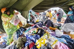 Hỗ trợ quần áo cho người dân vùng bị ảnh hưởng mưa lũ ở phường Tây Nha Trang (Khánh Hòa). (Ảnh: Nguyễn Thành/TTXVN)