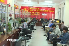 Cán bộ, công chức xã Bà Điểm (Thành phố Hồ Chí Minh) làm việc xuyên trưa giải quyết hồ sơ hành chính phục vụ người dân. (Ảnh: Hữu Duyên/TTXVN)