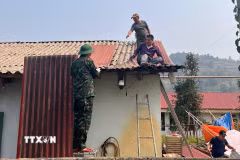 Cán bộ, chiến sỹ Bộ Chỉ huy quân sự tỉnh Lào Cai giúp bà con xã Bắc Hà lợp lại mái nhà, nhanh chóng ổn định cuộc sống sau trận mưa đá. (Ảnh: TTXVN phát)