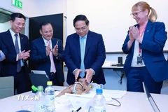 Thủ tướng Phạm Minh Chính thực hành mô phỏng cấp cứu trẻ sinh non theo quy trình và phương pháp của Viện Y khoa Karolinska. (Ảnh: Dương Giang/TTXVN)