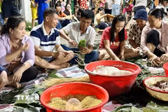 Người dân khắp nơi đổ về nhà văn hóa khu phố 3A, phường Trảng Dài, tỉnh Đồng Nai để gói hàng ngàn bánh chưng, bánh tét gửi đi cứu trợ vùng lũ. (Ảnh: Lê Xuân/TTXVN)