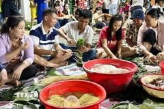 Người dân khắp nơi đổ về nhà văn hóa khu phố 3A, phường Trảng Dài, tỉnh Đồng Nai để gói hàng ngàn bánh chưng, bánh tét gửi đi cứu trợ vùng lũ. (Ảnh: Lê Xuân/TTXVN)