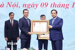Thủ tướng Phạm Minh Chính trao Huân chương Lao động hạng Ba cho doanh nghiệp có thành tích xuất sắc. (Ảnh: Dương Giang/TTXVN)