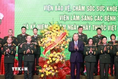 Tổng Bí thư Tô Lâm tặng hoa chúc mừng đội ngũ giáo sư, bác sỹ Bệnh viện Trung ương Quân đội 108. (Ảnh: Thống Nhất/TTXVN)