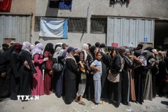 Người dân Palestine tập trung tại một điểm phân phát hàng cứu trợ ở Gaza. (Ảnh: THX/TTXVN)