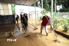 Người dân Nghệ An vệ sinh khắc phục hậu quả lũ lụt để sớm ổn định cuộc sống, sinh hoạt. (Ảnh: Xuân Tiến/TTXVN)