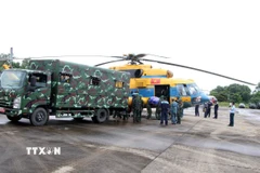 Lực lượng cứu trợ vận chuyển mỳ tôm, lương khô, nước... lên trực thăng để chuyển đến các xã phía Tây Nghệ An đang bị cô lập. (Ảnh: Văn Tý/TTXVN)