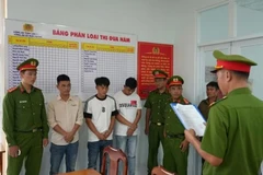 Ba bị can nghe công an tống đạt quyết định khởi tố và lệnh bắt tạm giam. (Nguồn: Công an tỉnh Lâm Đồng).