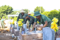 Chiến sỹ Bộ Chỉ huy Quân sự tỉnh Điện Biên tỉ mỉ hoàn thiện công đoạn trát vữa, cố định các hạng mục phần mộ sau khi lấy mẫu sinh phẩm xác định danh tính hài cốt liệt sỹ. (Ảnh: Xuân Tư/TTXVN)