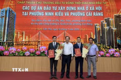 Phó Chủ tịch Ủy ban Nhân dân thành phố Cần Thơ Nguyễn Văn Hòa (giữa) trao quyết định chủ trương đầu tư xây dựng 2 dự án Nhà ở xã hội. (Ảnh: Nguyễn Văn Việt/TTXVN)