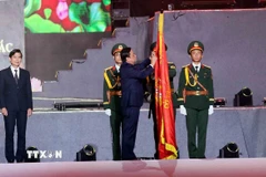 Phó Chủ tịch Quốc hội Lê Minh Hoan gắn Huân chương Lao động hạng Nhất lên cờ truyền thống của tỉnh Sơn La. (Ảnh: Quang Quyết/TTXVN)