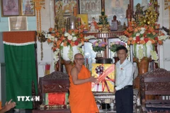 Chủ tịch Hội đồng Dân tộc của Quốc hội Lâm Văn Mẫn tặng quà cho Hòa thượng Hữu Hinh, Trụ trì chùa Ghositaram (xã Hưng Hội, tỉnh Cà Mau). (Ảnh: Chanh Đa/TTXVN)