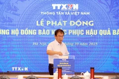Phó Tổng Giám đốc TTXVN Nguyễn Tuấn Hùng ủng hộ đồng bào khắc phục hậu quả bão lũ. (Ảnh: Tuấn Anh/TTXVN)