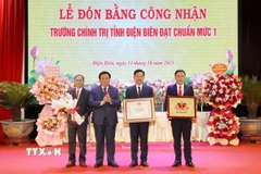 Ông Nguyễn Xuân Thắng trao Bằng công nhận đạt chuẩn mức độ 1 cho Ban Giám hiệu nhà trường. (Ảnh: Trung Kiên/TTXVN)