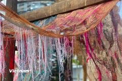 Những giá trị vật chất và tinh thần của dân tộc Thái như chiếc khăn piêu, nghề dệt vải, may vá, khâu thêu truyền thống được sử dụng làm chất liệu cho tác phẩm nghệ thuật. (Nguồn: Vietnam+)