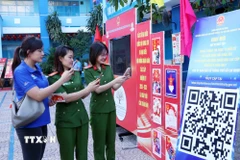 Cử tri trẻ Thành phố Hồ Chí Minh quét mã QR để tham gia cuộc thi tìm hiểu về Luật Bầu cử trực tuyến. (Ảnh: Xuân Khu/TTXVN)