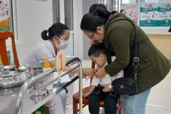 Phụ huynh đưa con đến tiêm vaccine phòng sởi. (Ảnh: Văn Dũng/TTXVN)