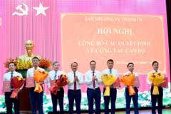Phó Bí thư Thường trực Thành ủy Nguyễn Đình Vĩnh (thứ tư, từ trái sang) và Chủ tịch UBND thành phố Nguyễn Mạnh Hùng (thứ năm, từ trái sang) tặng hoa chúc mừng các đồng chí được điều động, bổ nhiệm và giao quyền.