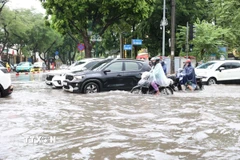 Các phương tiện di chuyển khó khăn trên đường Xuân Tảo. (Ảnh: Vietnam+)