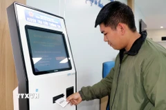 Áp dụng phần mềm lấy số thứ tự tại Trung tâm Phục vụ hành chính công một cấp tại Quảng Ninh. (Ảnh: Văn Đức/TTXVN)
