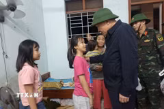 Phó Thủ tướng Thường trực Nguyễn Hòa Bình động viên các cháu học sinh được các lực lượng ứng cứu từ vùng ngập sâu. (Ảnh: Tuấn Anh/TTXVN)
