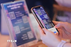 Du khách sử dụng điện thoại thông minh quét mã QR Code tìm kiếm thông tin về các điểm du lịch, điểm tham quan, ẩm thực… (Ảnh: Minh Quyết/TTXVN)