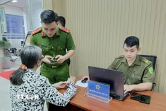 Công an hướng dẫn người dân tại bộ phận một cửa. (Ảnh: Linh Sơn/TTXVN)