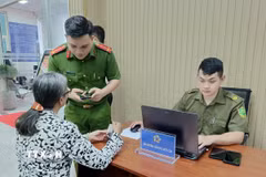 Công an hướng dẫn người dân tại bộ phận một cửa. (Ảnh: Linh Sơn/TTXVN)