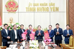 Phó Bí thư Tỉnh ủy, Chủ tịch Ủy ban Nhân dân tỉnh Phạm Quang Ngọc trao các quyết định và tặng hoa chúc mừng các đồng chí được điều động, bổ nhiệm chức vụ mới. (Ảnh: Nguyễn Công Hải/TTXVN)