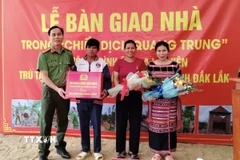 Lãnh đạo Công an tỉnh Đắk Lắk tặng quà cho hộ gia đình ông La Lan Yên (thôn Xí Thoại, xã Xuân Lãnh) vừa có nhà mới trong "Chiến dịch Quang Trung." (Ảnh: Tường Quân/TTXVN)