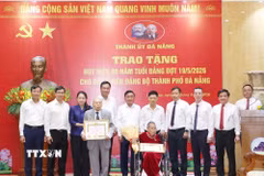 Thường trực Ban Bí thư Trần Cẩm Tú trao Huy hiệu 80 năm tuổi Đảng cho các đảng viên cao tuổi thành phố Đà Nẵng. (Ảnh: Phương Hoa/TTXVN)