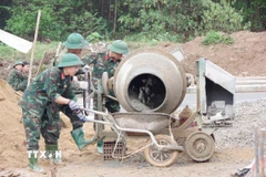 Các chiến sỹ Trung đoàn 6, Bộ Chỉ huy Quân sự thành phố Huế hỗ trợ giúp người dân xã Khe Tre xây dựng nhà mới. (Ảnh: Mai Trang/TTXVN)