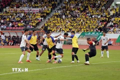 Trận thi đấu giao hữu giữa đội cán bộ công chức thành phố (áo trắng) với đội đội văn nghệ sỹ thành phố (áo vàng). (Ảnh: Trung Tuyến/TTXVN)