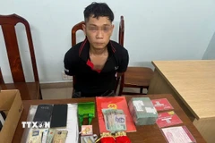 Đối tượng Đỗ Tấn Được cùng tang vật vụ án. (Ảnh: TTXVN phát)