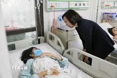 Chủ tịch Ủy ban Mặt trận Tổ quốc Việt Nam thành phố Hà Nội Bùi Huyền Mai thăm hỏi, động viên nạn nhân bị thương trong vụ tai nạn giao thông nghiêm trọng tại Lào Cai. (Ảnh: Minh Nghĩa/TTXVN)