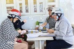 Các hộ dân xã Phước Hậu (tỉnh Khánh Hòa) có nhà bị ngập trong đợt lũ vừa qua được hỗ trợ 1 triệu đồng mỗi người. (Ảnh: Nguyễn Thành/TTXVN)