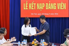 Bí thư Chi bộ Ngữ văn 3 trao quyết định kết nạp cho đảng viên mới. (Ảnh: Thanh Tùng/TTXVN)