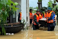 Lực lượng Bộ đội Biên phòng thành phố Đà Nẵng giúp dân vùng lũ vận chuyển tài sản đến nơi an toàn. (Ảnh: Trần Tĩnh/TTXVN)