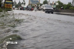 Triều cường dâng cao ảnh hưởng đến việc lưu thông các phương tiện trên Quốc lộ 1A đoạn qua thành phố Cần Thơ. (Ảnh: Tuấn Phi/TTXVN)