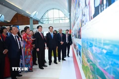 Bí thư Đảng ủy, Tổng Giám đốc TTXVN Vũ Việt Trang giới thiệu với Chủ tịch nước Lương Cường, nguyên Thủ tướng Nguyễn Tấn Dũng và các đại biểu về triển lãm ảnh. (Ảnh: Dương Giang/TTXVN)