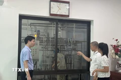 Tiến sỹ Vũ Xuân Dương (áo xanh) kiểm tra dây chuyển sản xuất sữa của Công ty cổ phần chăn nuôi và chế biến sữa Vĩnh Thịnh. (Ảnh: Nguyễn Thảo/TTXVN)