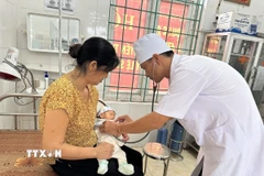 Bác sỹ Trạm y tế Trung Nguyên, xã Tề Lỗ (Phú Thọ) khám cho bệnh nhi. (Ảnh: Nguyễn Thảo/TTXVN)