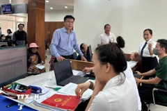 Cán bộ Trung tâm hành chính công phường Tam Kỳ, thành phố Đà Nẵng, hướng dẫn người dân làm thủ tục hành chính. (Ảnh: Trần Tĩnh/TTXVN)