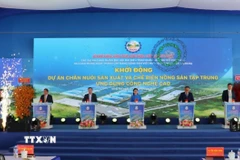Ủy viên Trung ương Đảng, Phó Bí thư Thường trực tỉnh uỷ, Chủ tịch HĐND tỉnh Đồng Nai Tôn Ngọc Hạnh và các đại biểu nhấn nút khởi động Dự án Chăn nuôi sản xuất và chế biến nông sản tập trung ứng dụng công nghệ cao. (Ảnh: Nhật Bình/TTXVN)