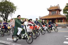 Chương trình quy tụ 200 người tham gia, mặc áo dài truyền thống và đạp xe qua nhiều tuyến đường. (Ảnh: Văn Dũng/TTXVN)