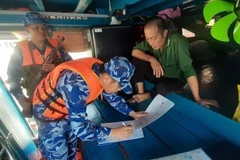 Lực lượng chức năng Bộ tư lệnh Vùng Cảnh sát biển 4 lập biên bản tạm giữ phương tiện chở dầu trái phép. (Ảnh: TTXVN phát)