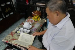 Ông Phan Văn Diệu xem lại nhật ký của mình. (Ảnh: Thanh Bình/TTXVN)